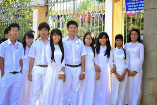 白いアオザイを着た女子学生と男子学生